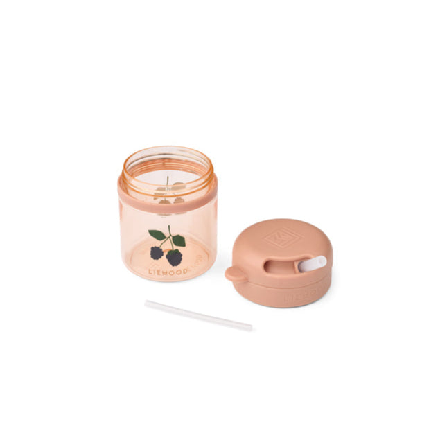 Small candle in a rose gold container with a matching lid on a white background